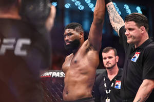 UFC拳手在八角籠中被裁判舉起慶祝勝利 — 終極格鬥冠軍賽 壁紙