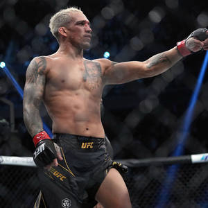 UFC拳手在八角籠內舉臂慶祝勝利。 — 終極格鬥冠軍賽 壁紙
