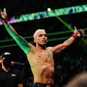UFC拳手在八角籠中高舉雙臂慶祝勝利。 — 終極格鬥冠軍賽 壁紙