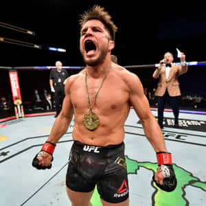 UFC拳手在八角籠中手持金牌慶祝勝利 — 終極格鬥冠軍賽 壁紙