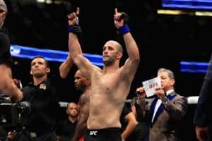 UFC拳手在八角籠中舉臂慶祝勝利。 — 終極格鬥冠軍賽 壁紙