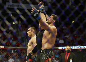 UFC拳手在八角籠內與裁判和對手一起慶祝勝利。 — 終極格鬥冠軍賽 壁紙