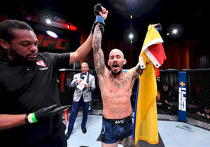 UFC拳手在八角籠內舉起手臂和旗幟慶祝勝利。 — 運動 壁紙