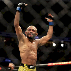 UFC拳手在八角籠內高舉雙臂慶祝勝利。 — 終極格鬥冠軍賽 壁紙
