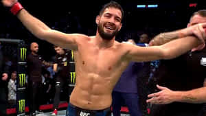UFC拳手在八角籠中高舉雙臂慶祝勝利。 — 極限運動 壁紙