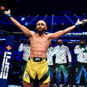 UFC拳手在八角籠內高舉雙臂慶祝勝利。 — 終極格鬥冠軍賽 壁紙