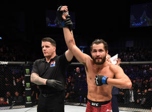 UFC拳手在八角籠內由裁判舉起手慶祝勝利。 — 終極格鬥冠軍賽 壁紙