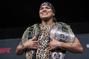 UFC拳手微笑著手持兩條冠軍腰帶。 — 終極格鬥冠軍賽 壁紙