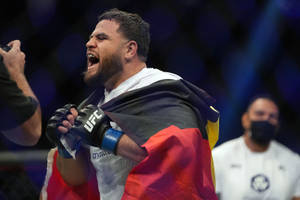 UFC拳手披著德國國旗在八角籠內慶祝勝利。 — 運動 壁紙