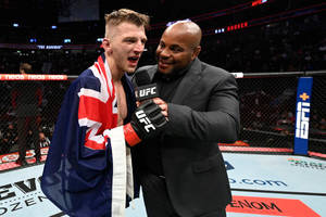 UFC拳手披著英國國旗在八角籠內與採訪者慶祝。 — 運動 壁紙