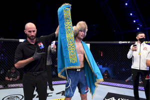 UFC拳手披著哈薩克旗幟在八角籠中慶祝勝利。 — 運動 壁紙