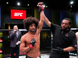 UFC拳手贏得比賽，裁判舉起他的手表示勝利。 — 終極格鬥冠軍賽 壁紙