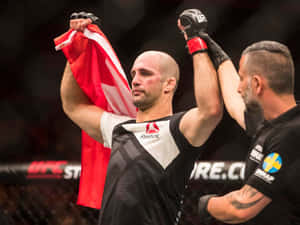 UFC拳手手持加拿大國旗慶祝勝利，裁判舉起他的手臂。 — 終極格鬥冠軍賽 壁紙