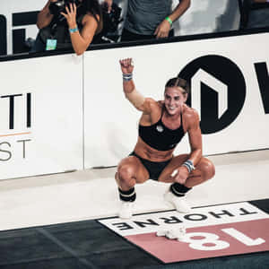 女性運動員舉起拳頭慶祝體育比賽勝利。 — 運動 壁紙