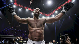 拳擊手在明亮的燈光下於擂台上高舉雙臂慶祝勝利。 — 運動 壁紙