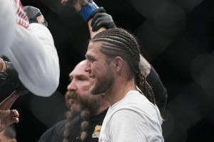 綁辮子的MMA拳手在場館與隊友慶祝勝利。 — 3:2 壁紙