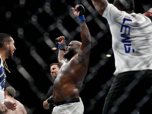 MMA拳手在八角籠內舉起拳頭慶祝勝利。 — 終極格鬥冠軍賽 壁紙