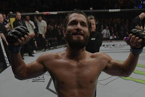MMA拳手在八角籠中高舉雙臂慶祝勝利。 — 終極格鬥冠軍賽 壁紙