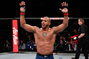 MMA拳手在八角籠中舉臂慶祝勝利。 — 終極格鬥冠軍賽 壁紙