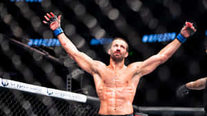 一位赤裸上身的MMA拳手在八角籠內高舉雙臂慶祝勝利。 — 終極格鬥冠軍賽 壁紙