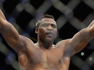 一位勝利的MMA拳手在籠內高舉雙臂。 — 勝利 壁紙