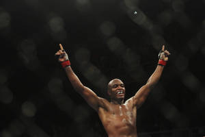 一位勝利的MMA拳手在黑暗的八角籠內舉臂歡呼。 — 酷 壁紙