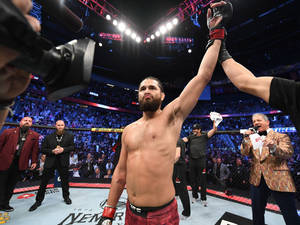 UFC拳手在八角籠中由裁判舉手慶祝勝利。 — 勝利 壁紙
