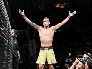 MMA拳手在UFC八角籠內高舉雙臂慶祝勝利。 — 終極格鬥冠軍賽 壁紙