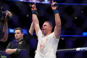 MMA拳手在八角籠內舉臂慶祝勝利。 — 運動 壁紙