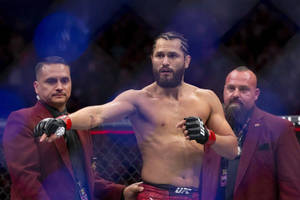 MMA 選手在八角籠中與官員一起慶祝勝利。 — 終極格鬥冠軍賽 壁紙