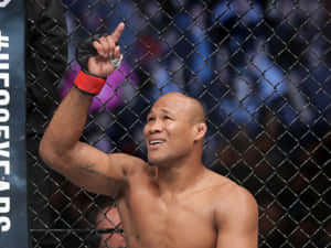 MMA 選手在八角籠內慶祝勝利，刺青清晰可見。 — 終極格鬥冠軍賽 壁紙