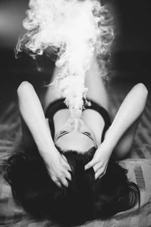 女士躺下閉眼呼出煙霧的黑白照片。 — 抽菸 壁紙