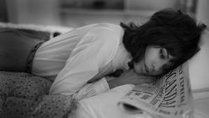 女士將頭靠在枕頭上在臥室閱讀報紙 — 報紙 壁紙