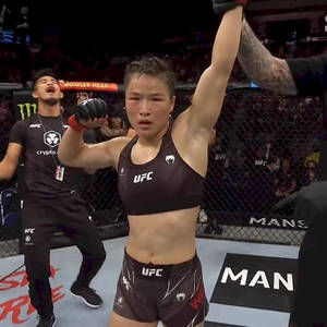 女性MMA拳手在UFC八角籠中與教練慶祝勝利。 — 運動 壁紙