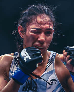 身穿UFC裝備的女性MMA拳手在比賽中展現決心。 — 運動 壁紙