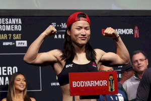 UFC拳手在稱重活動中展示肌肉並手持BodyArmor標誌 — 運動 壁紙