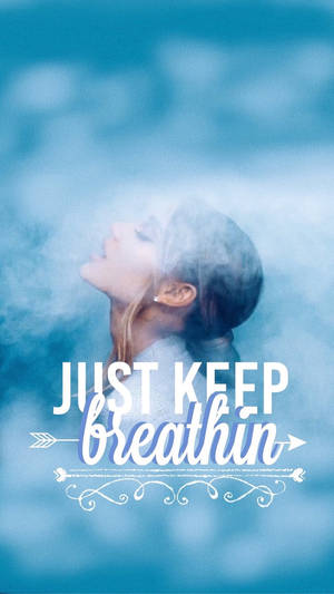 女性呼出煙霧，帶有藍色調的「just keep breathin」文字。