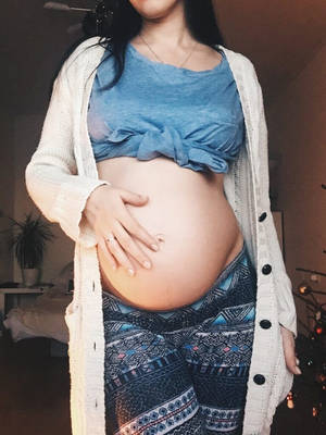 孕婦在節日期間在家裡觸摸肚子。 — 懷孕 壁紙