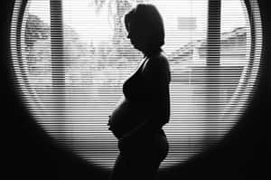 孕婦剪影捧著腹部在窗邊有百葉窗 — 懷孕 壁紙