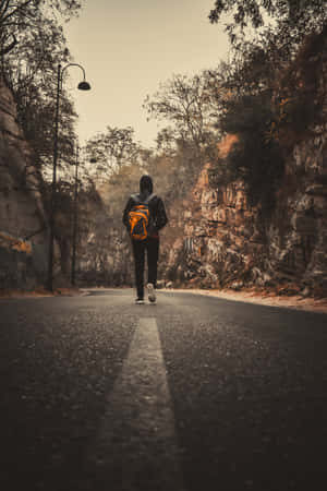 一個人獨自走在蜿蜒的道路上，穿越岩石景觀。 — 獨自一人 壁紙