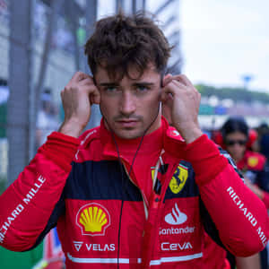 F1車手穿著紅色法拉利裝備在賽道上調整耳機。 — 巴林 壁紙