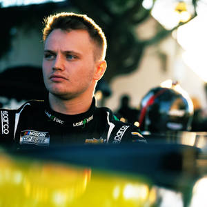 NASCAR車手穿著賽車服在日落中專注地凝視 — 人物 壁紙