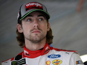 身穿Ford賽車裝備的NASCAR車手專注地向上凝視。 — 賽車 壁紙