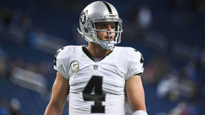 NFL四分衛在夜間足球場上穿著Raiders球衣4號。