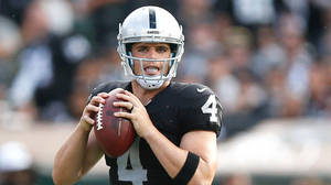 穿著Raiders隊服的NFL四分衛在比賽中準備投擲橄欖球。 — 運動 壁紙
