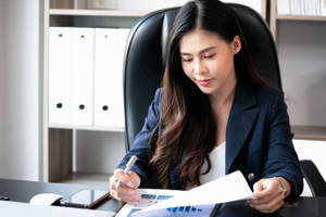 女商人在現代辦公桌上簽署文件。 — 工作 壁紙