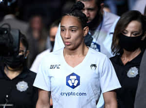 身穿白色球衣的女性UFC拳手在體育賽事中經過保安人員。 — 終極格鬥冠軍賽 壁紙