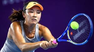 女網球選手在紫色球場上用藍色球拍擊打綠色球。 — 運動 壁紙