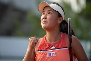 身穿橙色服裝的女網球選手在比賽中握緊拳頭。 — 網球 壁紙