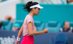 女網球選手在球場上握拳慶祝勝利。 — 運動 壁紙